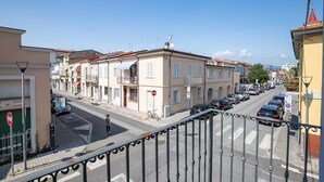 Une vue de rue avec des bâtiments, des voitures et un passage piéton.