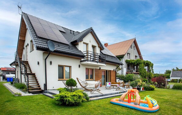 A two-story house with a balcony, a small garden, and an inflatable pool. - 1 bedroom pet friendly apartment in Nowecin (Nowecin)