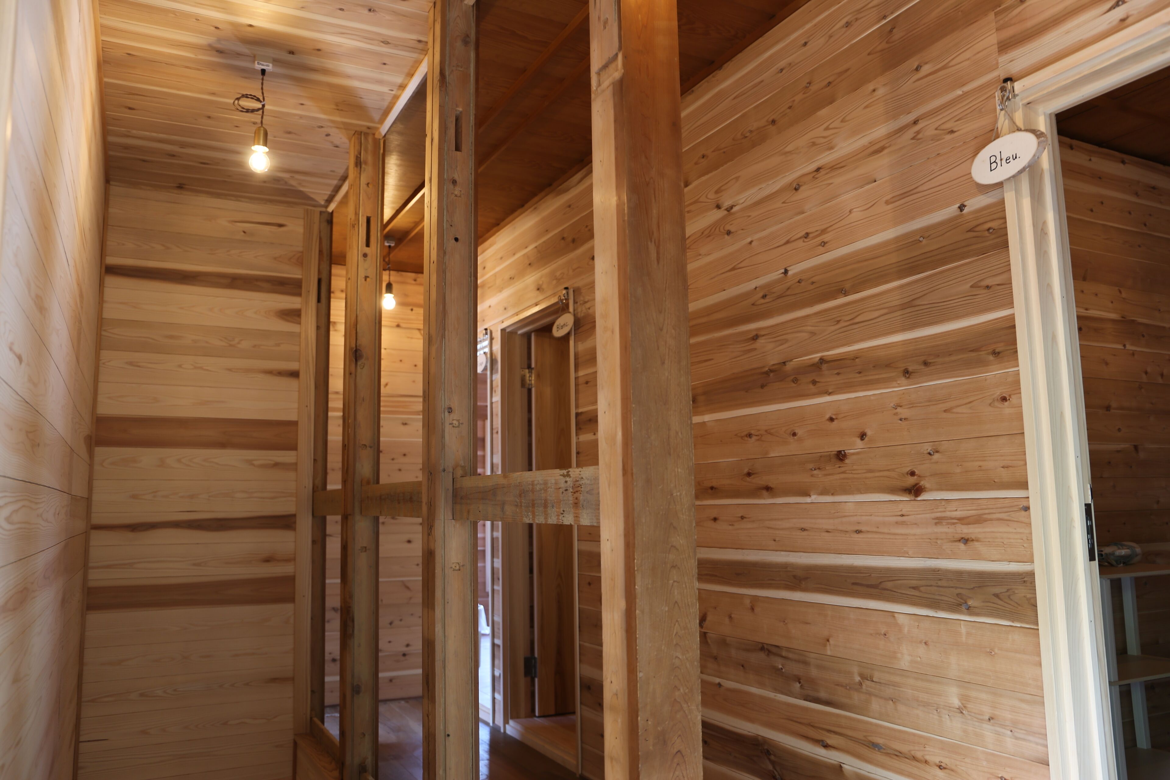 A wooden interior with exposed beams and a hanging light fixture.