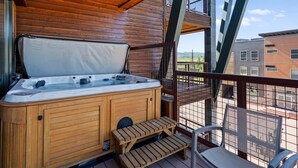 Ein Holzbott auf einem Balkon mit Blick auf Gebäude und einem klaren Himmel.