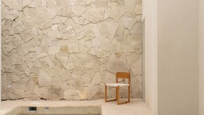 A stone wall, a wooden chair, and a small pool. - Villa Victoria Xico (Xico)