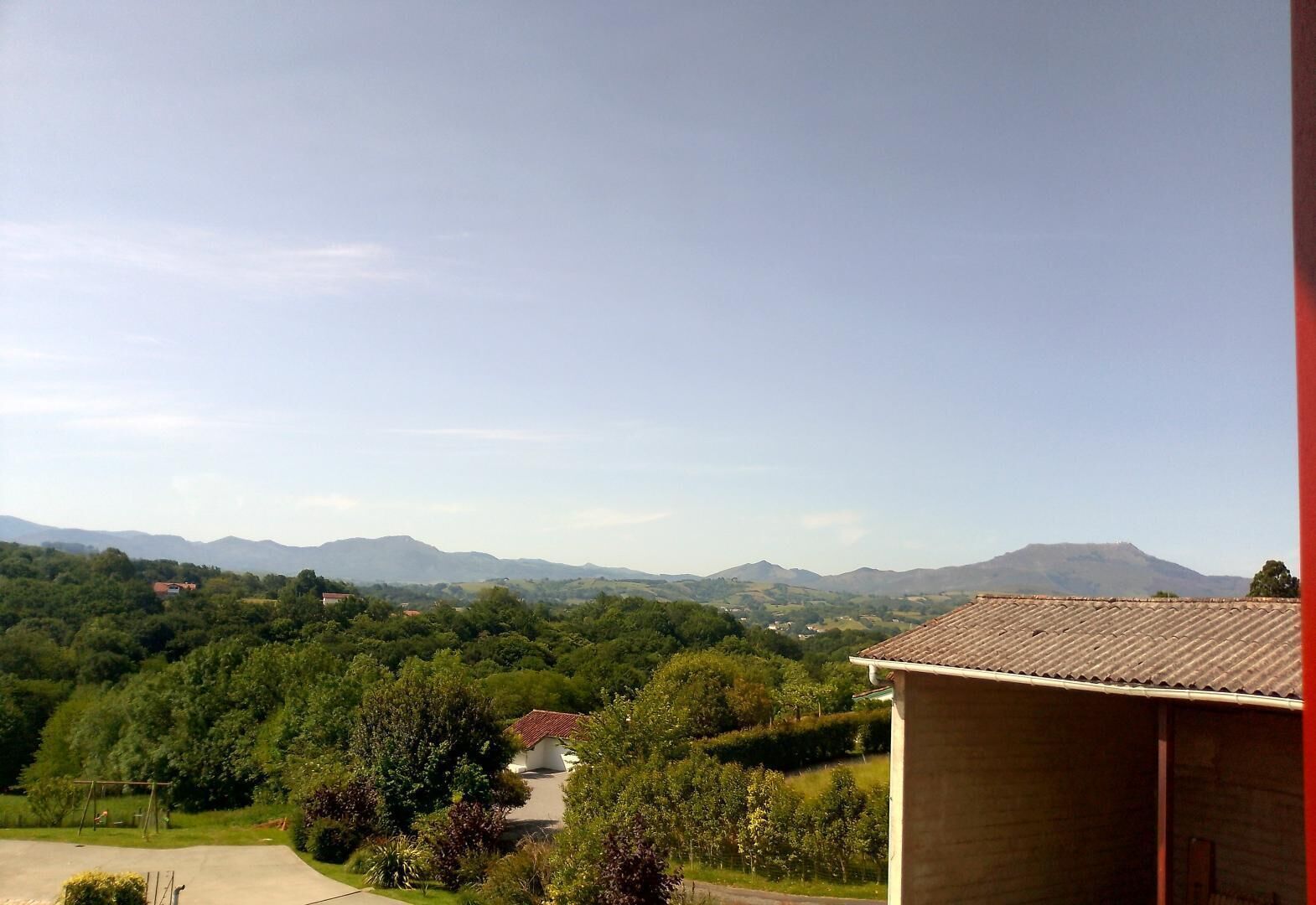Ein Blick auf eine gebirgige Landschaft mit einem Gebäude im Vordergrund.