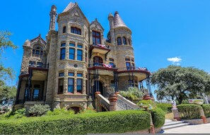 A large, ornate building with multiple towers and balconies, surrounded by well-maintained gardens. - Restored Historic Loft - 3 Mins to the Beach (Galveston)