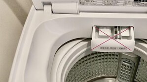 A front view of a white front-loading washing machine with a control panel displaying various settings and a water level indicator.