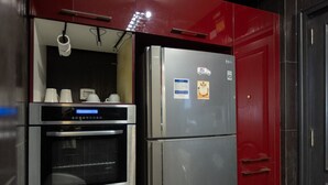 A kitchen with a built-in oven and a stainless steel refrigerator. - Nile Haven Zamalek Island 3BR (Cairo Governorate)