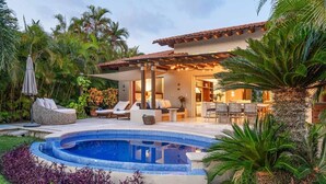 A private pool with lounge chairs and a covered patio area.