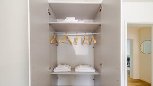 A walk-in closet with multiple shelves, a hanging rod, and a mirror. - Blueground | Basel-Vorstaedte, view, nr Rhine (Basel)