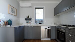Eine moderne Küche mit grauen Schränken, einem Edelstahl-Geschirrspüler und einem Backofen.