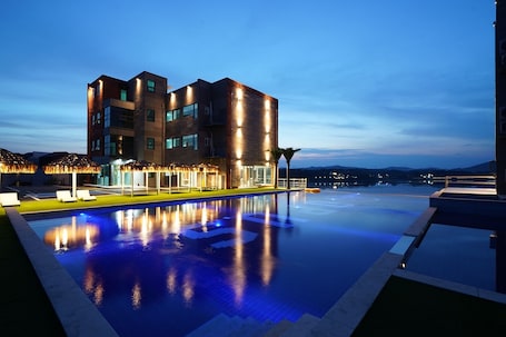 Una piscina al aire libre de temporada, sombrillas