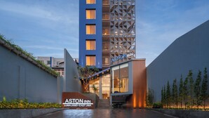 Un hôtel moderne à l’architecture verticale remarquable, caractérisé par un mélange de verre et de motifs géométriques.