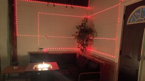 Una habitación acogedora con un sofá, una mesita con una vela y una planta.