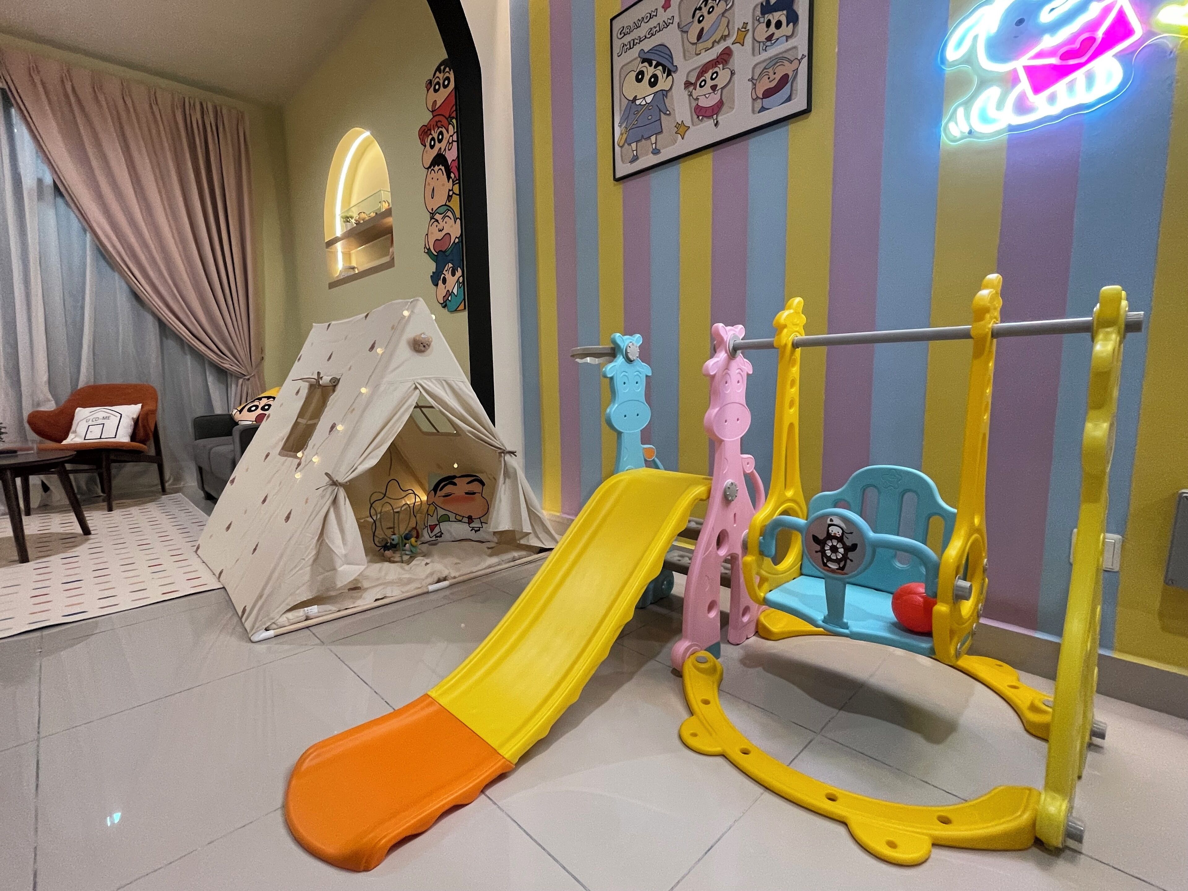 Un espace de jeux pour enfants avec un toboggan, une structure d’escalade et une tente.