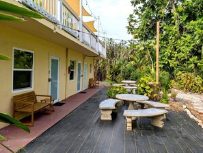 A yellow building with a balcony, outdoor seating, and a garden area. - Garden 1 bedroom in Esperanza, close to everything (Vieques)
