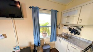 Una cocina compacta con ventana, un fregadero y una estufa.