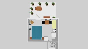 Una habitación con cama, mesita de noche, lámpara y una ventana pequeña.