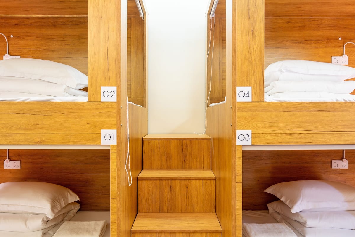 A bunk bed room with wooden walls and numbered beds.