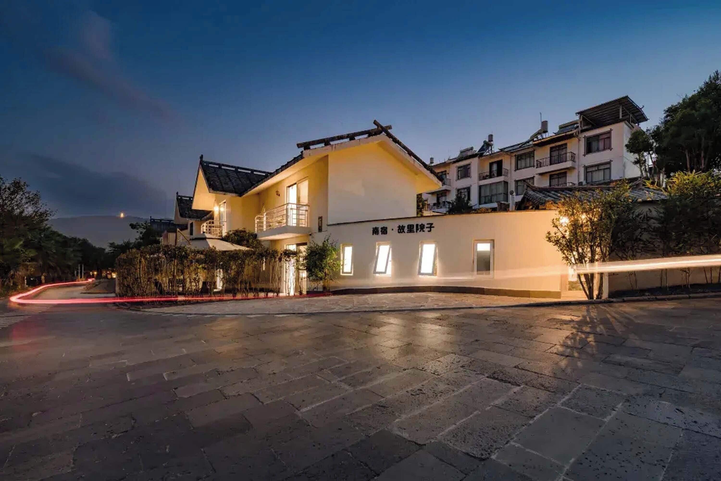 A hotel with a modern design, featuring a prominent entrance and a well-lit facade.