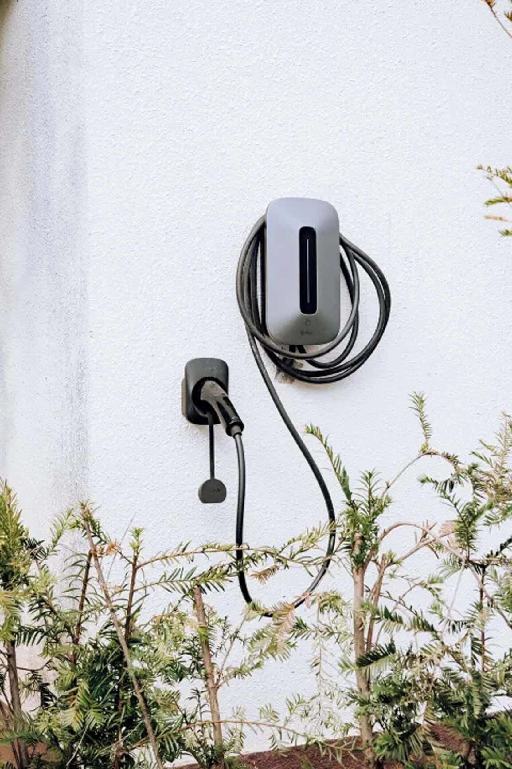 A wall-mounted power outlet with a cable connected to a device.