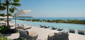 A poolside area with lounge chairs and umbrellas, overlooking a clear blue sea. - Laguna 3BR Beachfront Condo (Thalang District)