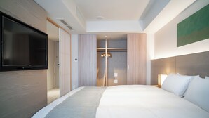 A modern hotel room with a large bed, a flat-screen TV, a walk-in closet, and a chandelier. - KIORI Collection Shinmachi (Kyoto)