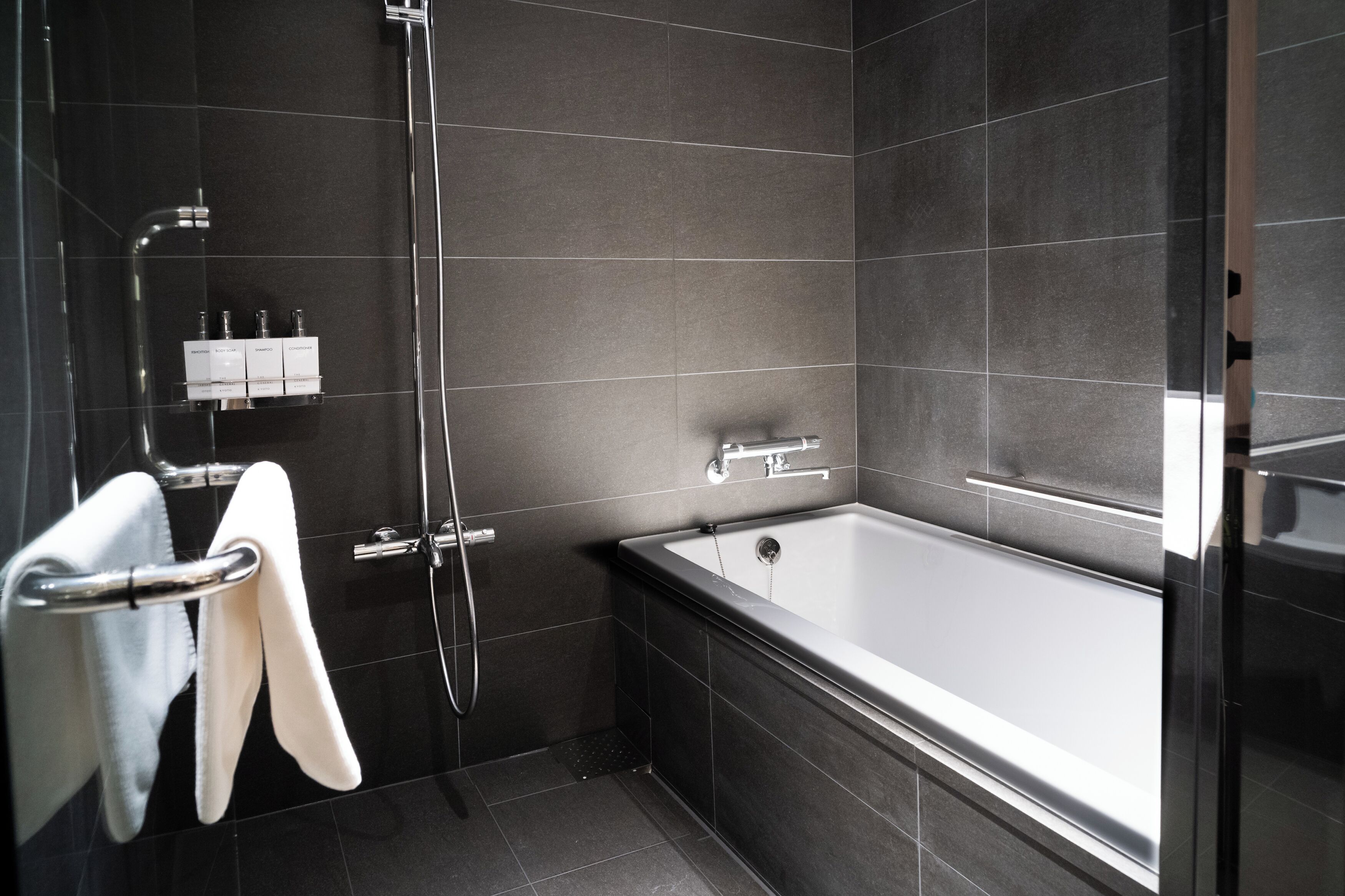Ein modernes Badezimmer mit Badewanne, Dusche und Handtuchhalter.