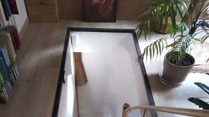 A wooden staircase with a glass railing, leading to a room with a wooden floor and a potted plant. - Master bedroom 50 m2 Great comfort 5 minutes from Lac de Neufond (Vergt)