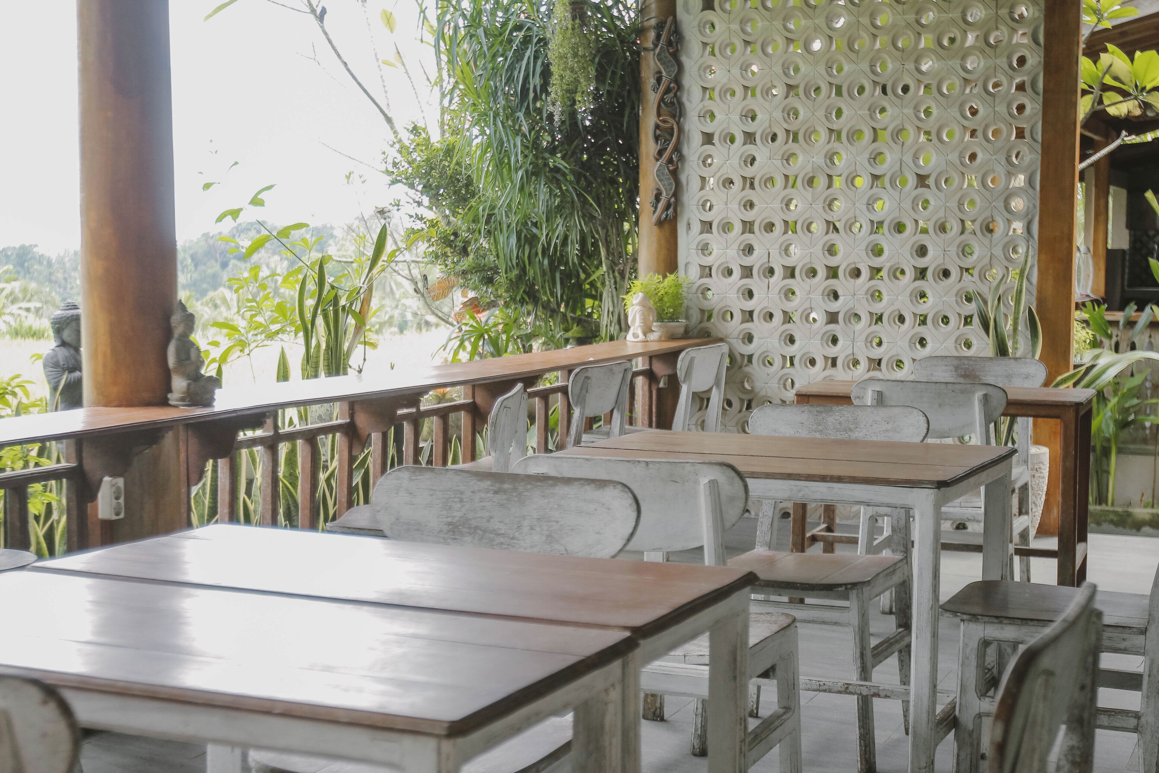 Un restaurant avec une terrasse, des tables et des chaises en bois.