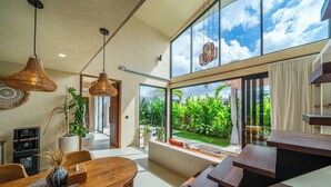 Um interior moderno com área de jantar, janelas amplas e uma escada.