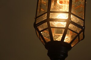 Een close-up van een zeshoekige lantaarn met een gedetailleerd patroon.