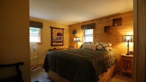 Un dormitorio con una cama, dos lámparas de noche, un cuadro en la pared y una ventana.