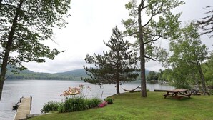 Un espacio de picnic junto al lago con un muelle de madera, una hamaca y una mesa para picnic.