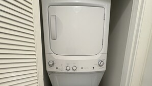 A front-loading washer and dryer unit with a ENERGY GUIDE label, located in a narrow hallway with a door on the left. - Charming Quiet 1-bedroom 1 bath ADU with AC, WiFi in Savannah (Savannah)