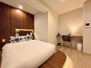 A modern hotel room with a large bed, a desk, a chair, a waste bin, and a lamp. - R34A9CC_903 / Koto-ku Tokyo (Koto-ku)