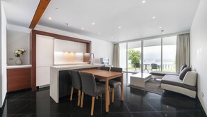 Une cuisine moderne avec un coin repas, un canapé et une vue sur l’extérieur.