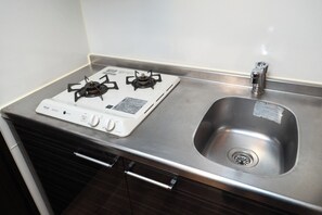 Kylskåp, mikrovågsugn, spishäll och grytor/köksredskap