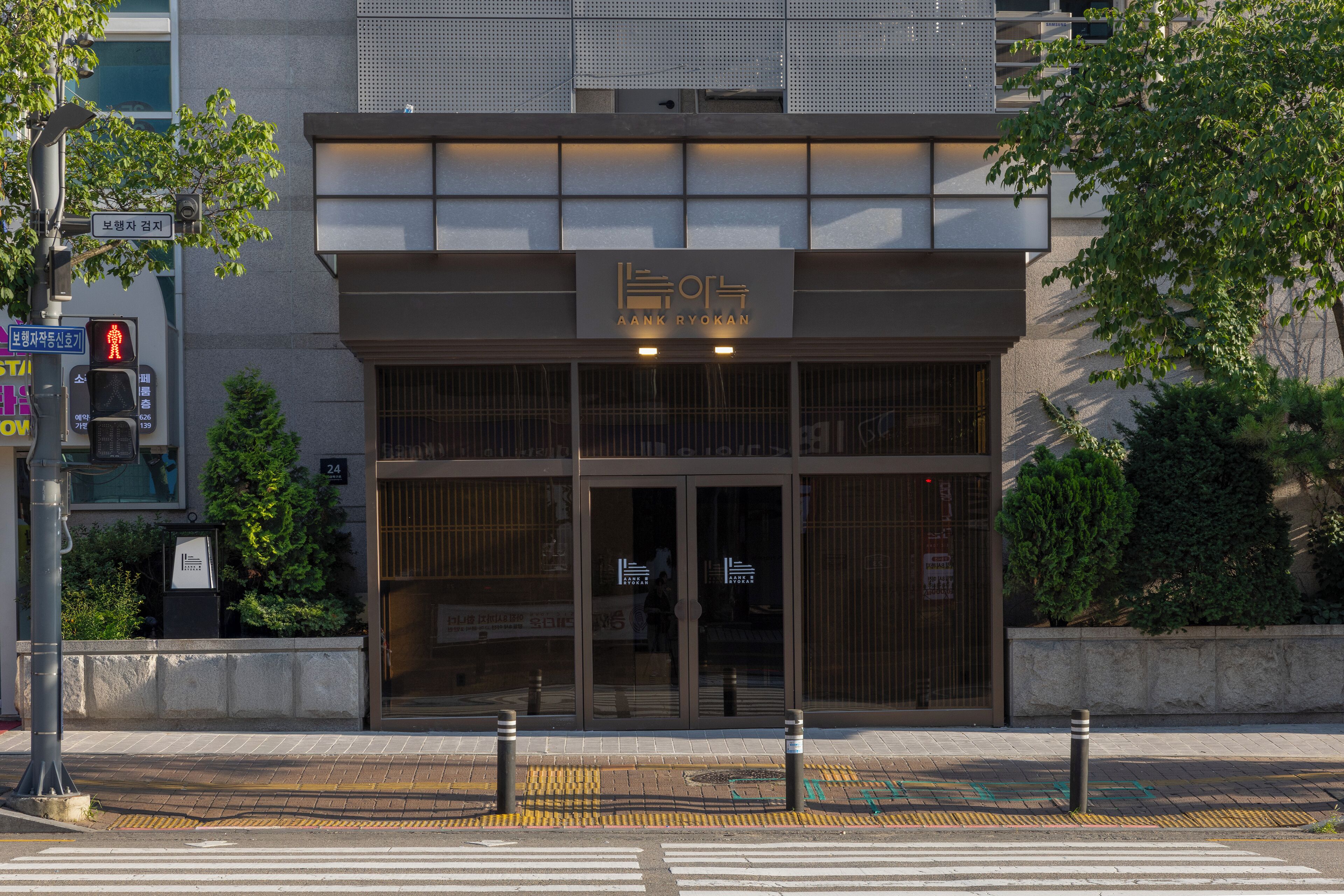 Een modern gebouw met een bord waarop 'AANK RYOKAN' staat.