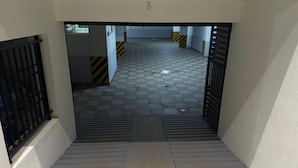 A stairway leading to a tiled corridor with striped walls and a light fixture at the top.