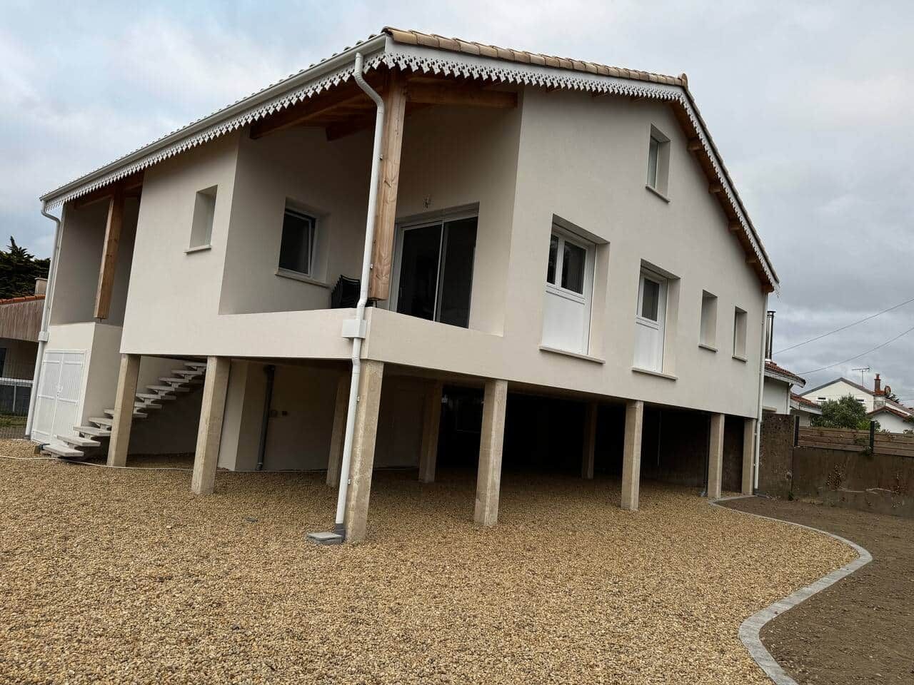 Un bâtiment à deux étages, doté d’un toit plat et d’une véranda couverte.