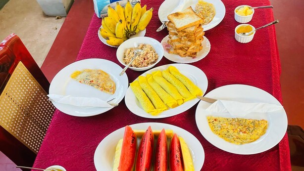 Una mesa dispuesta con diversos alimentos para el desayuno, como huevos, tostadas y fruta.