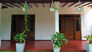 Un porche cubierto con macetas y jardineras colgantes.
