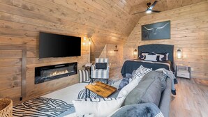 A cozy log cabin room with a fireplace, a bed, a sofa, and a television mounted on the wall. - Romantic Sunsets Couples A Frame H/T Buffalo River (Parthenon)
