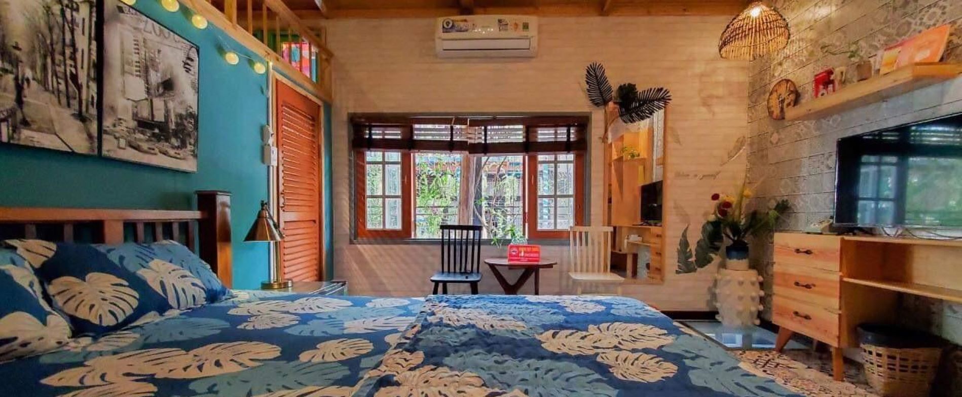 Un dormitorio con una cama grande, una silla, una mesita y un televisor.
