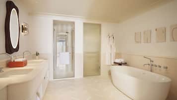 A modern bathroom with a freestanding bathtub, a large mirror, and a vanity with two sinks.
