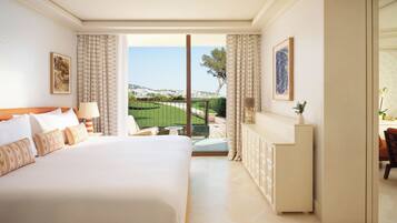 A hotel room with a large bed, a small table, a sofa, a cabinet, and a balcony with a view.