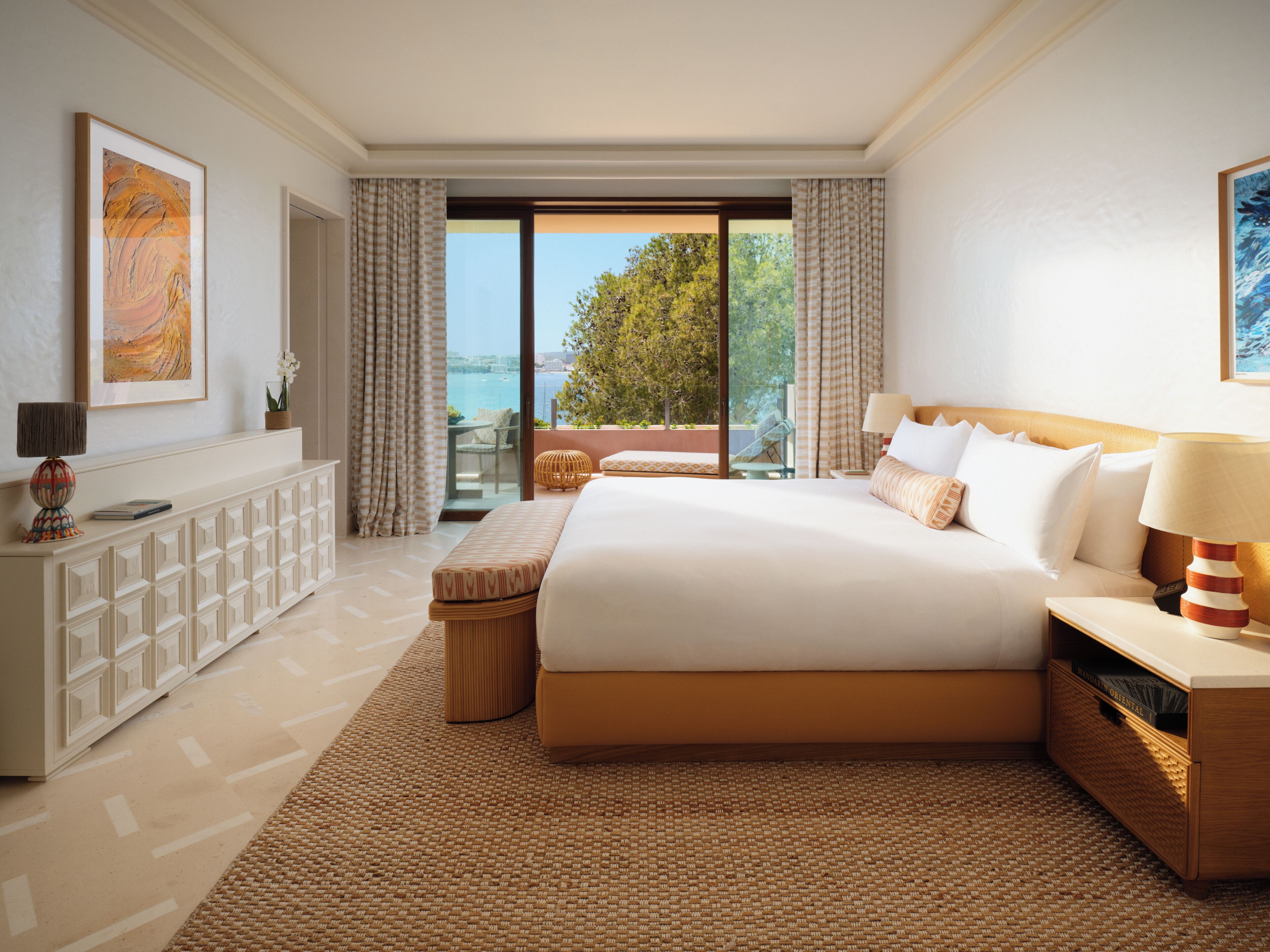 Une chambre d’hôtel avec un grand lit, un canapé, un bureau et une vue sur l’extérieur.