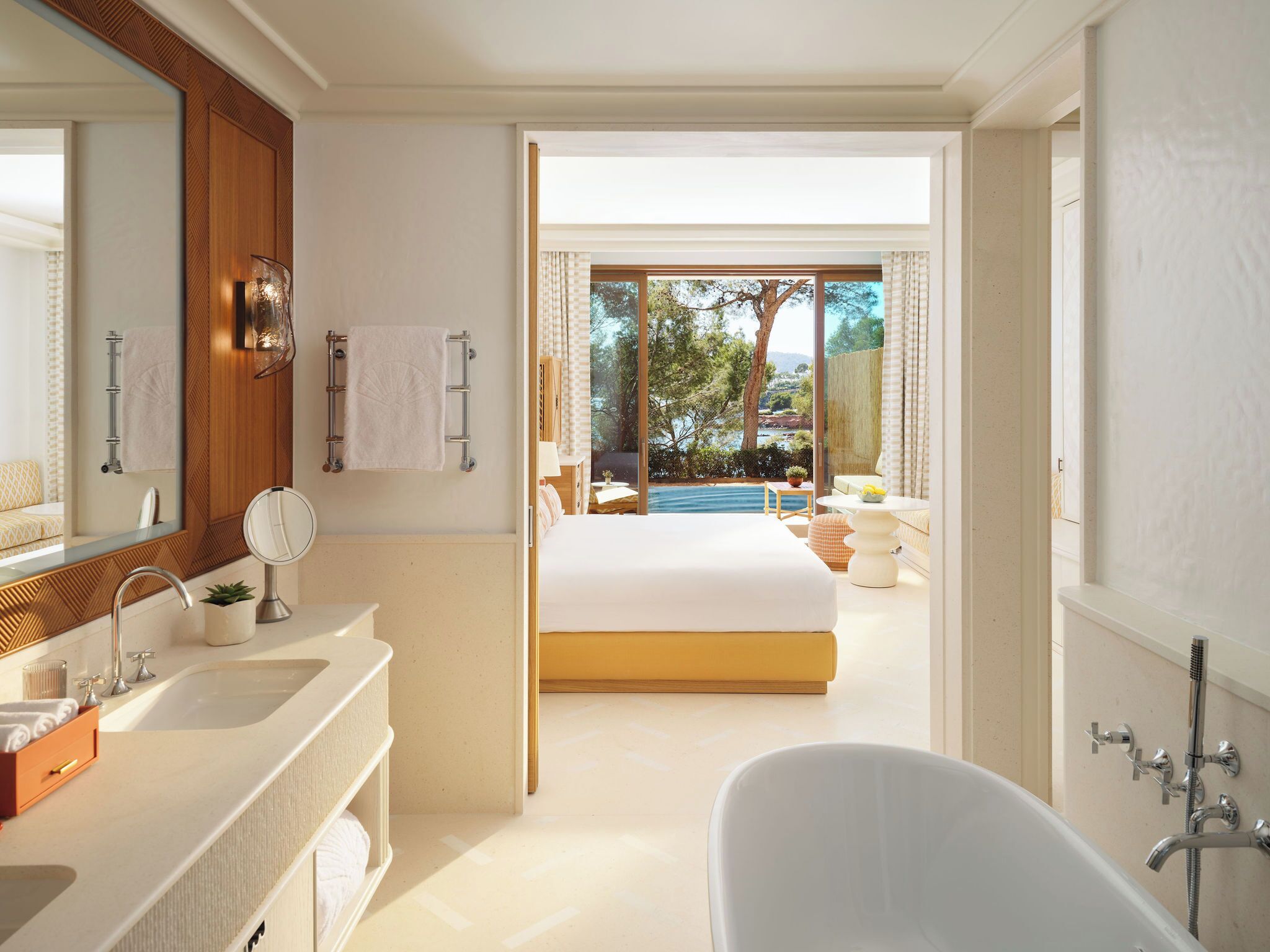 A modern bathroom with a bathtub, a large mirror, and a sink.