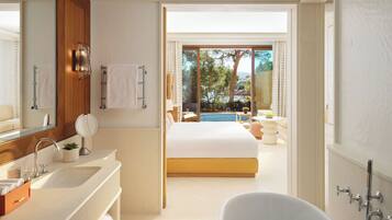 A modern bathroom with a bathtub, a large mirror, and a sink.