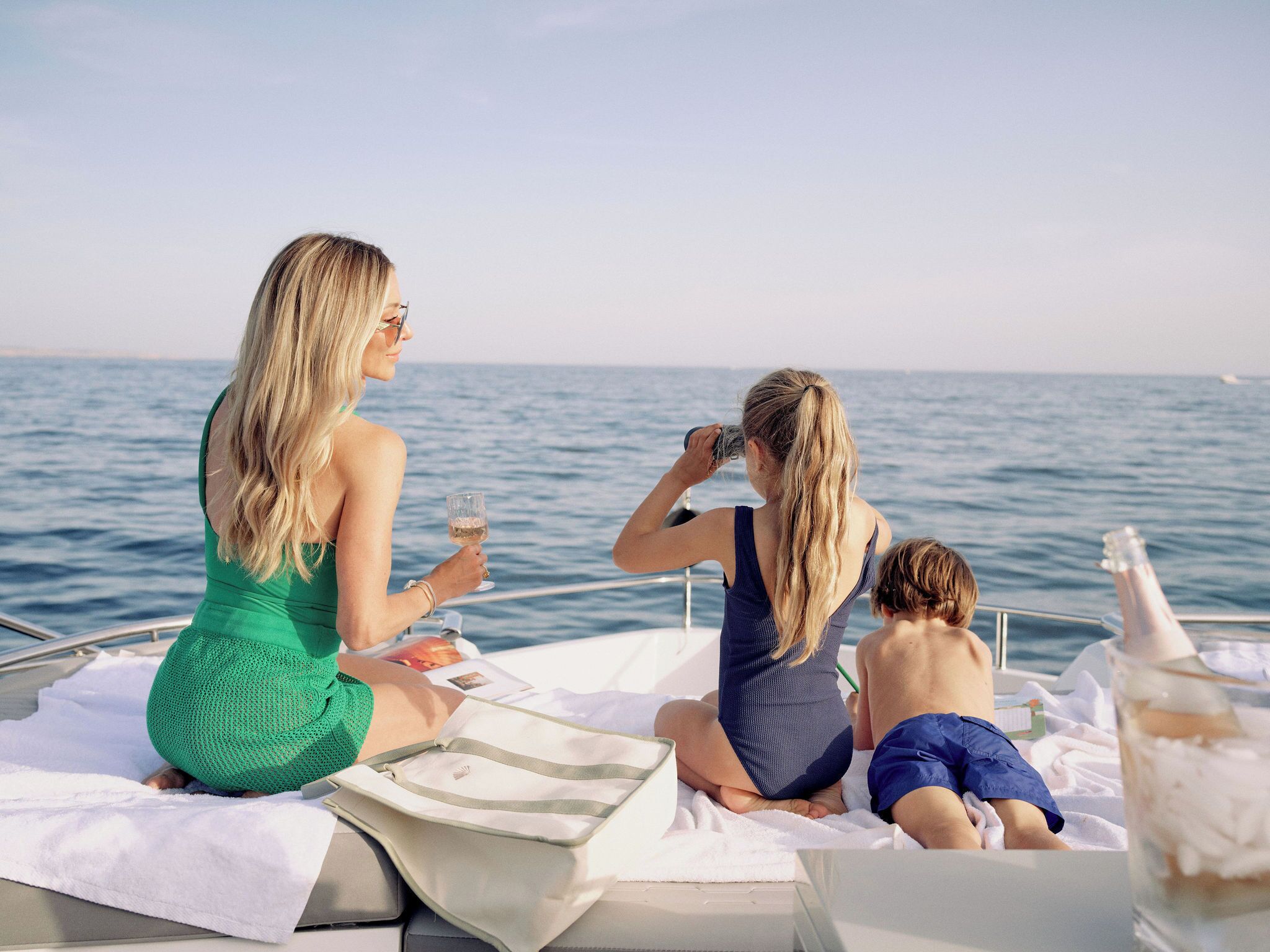 Three people on a boat with a view of the sea.