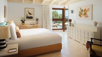 Una habitación de hotel con una cama grande, una mesita de noche, un escritorio, una silla, una ventana con cortinas y vistas al exterior.