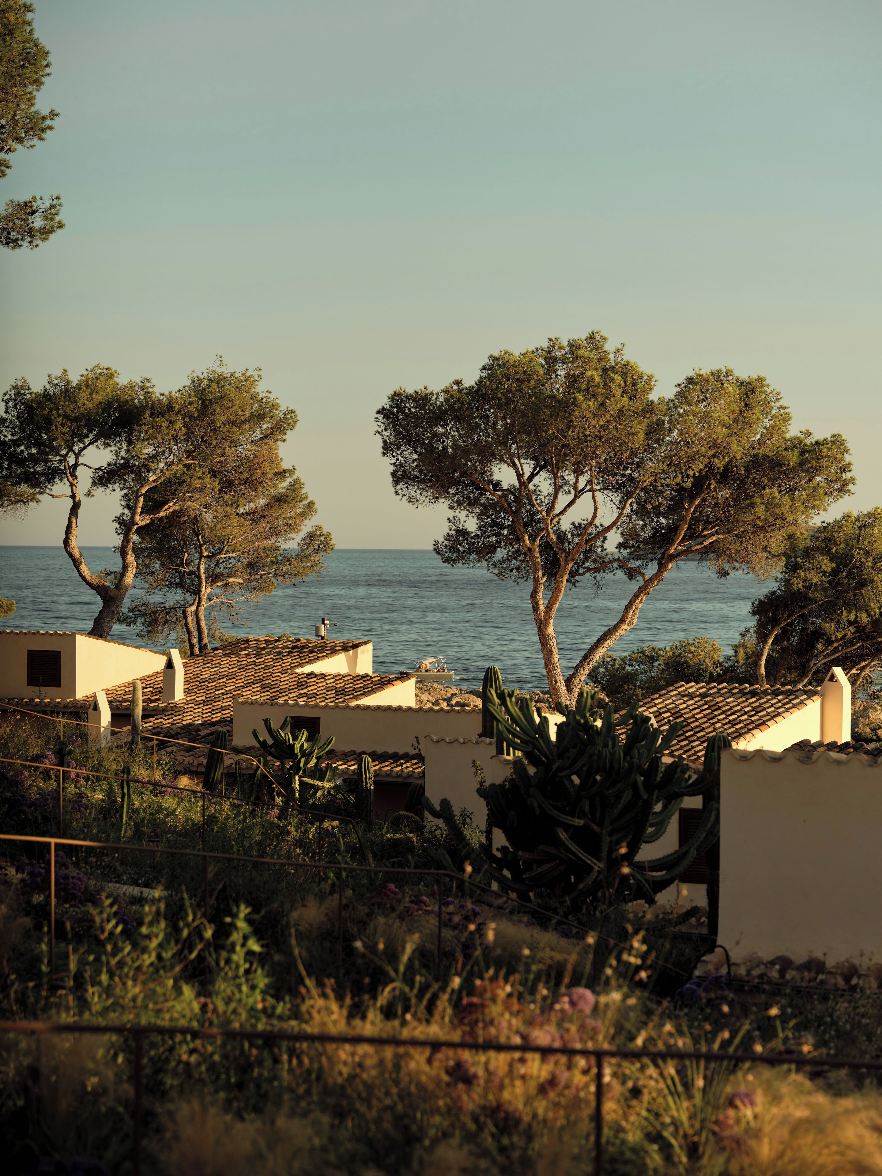 A coastal property with Mediterranean-style architecture, including terracotta-tiled roofs and stucco walls.